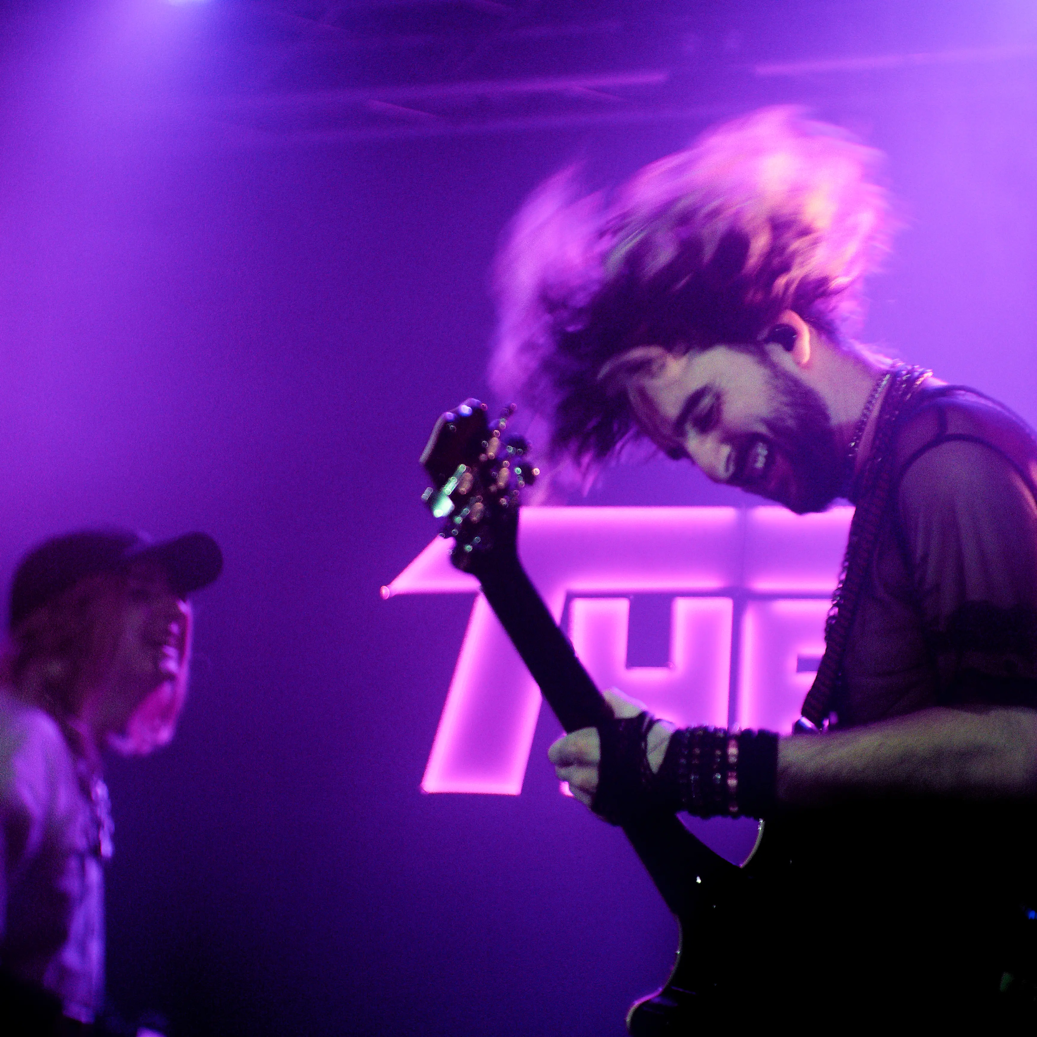 Adlib et Théa face au logo lumineux de Théa Montana, lumière violette