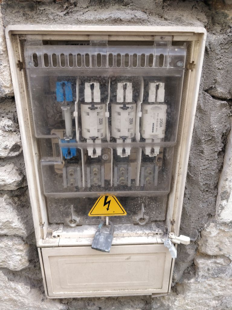 Boitier électrique de rue sans le couvercle, on y voit l’intérieur avec des sortes de fusible parqué de « 200A »