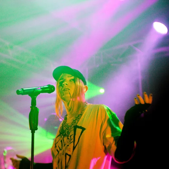 Photo de Théa en concert, dans des lumières violettes et vertes