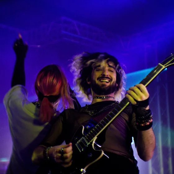 Adlib joue de la guitare dos à Théa