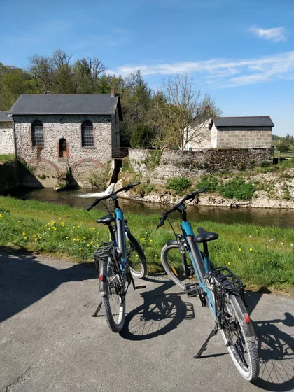 Deux vélos bleu devant un moulin à eau