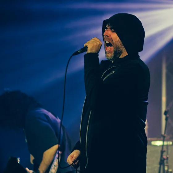 Le chanteur du groupe micro à la main dans une lumière bleu