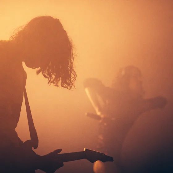 A ganche le musicien qui fait de la guitare et à droite dans la fumée la chanteuse qui dance